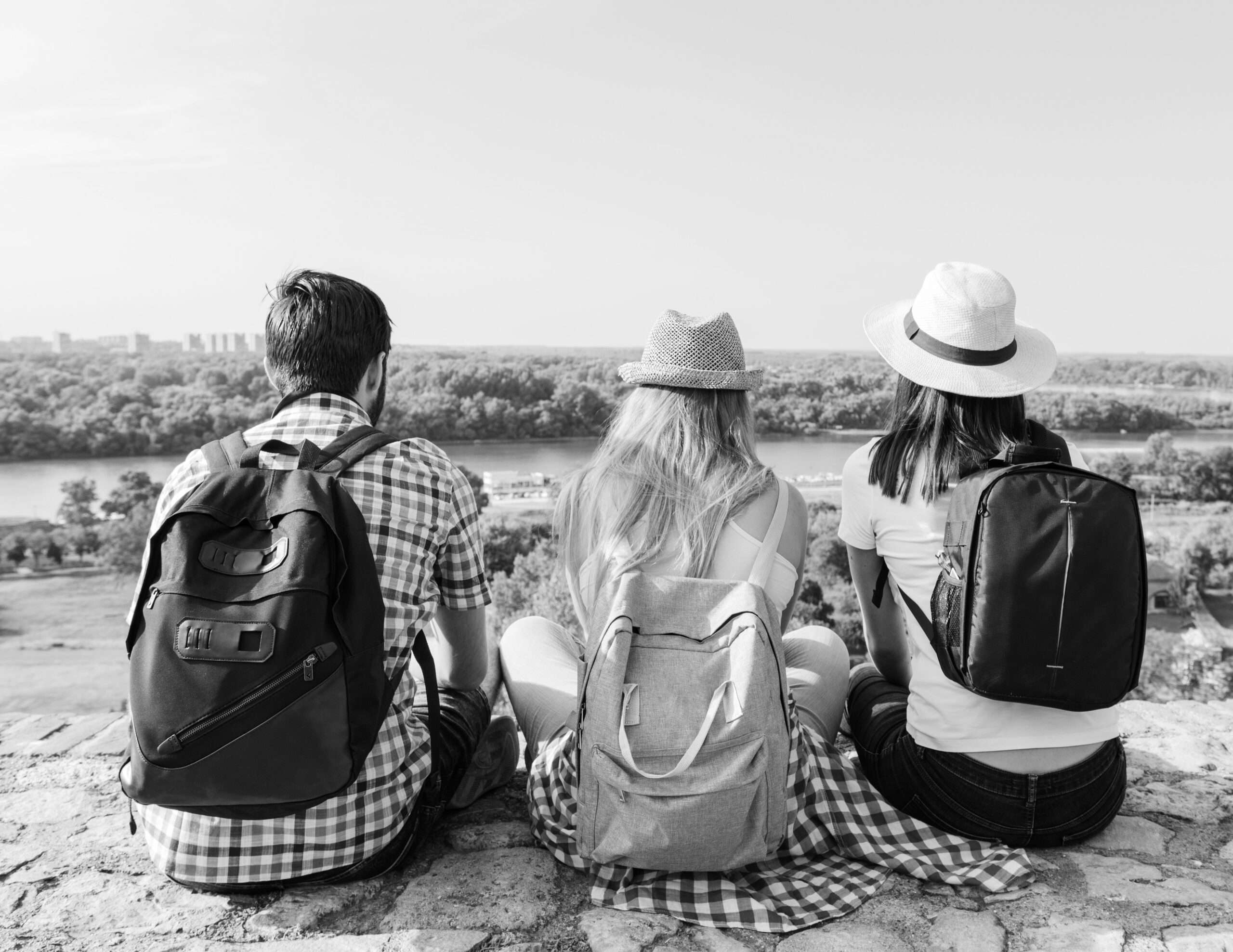 Groupe de trois personnes jeunes de dos regardant passer les bateaux
